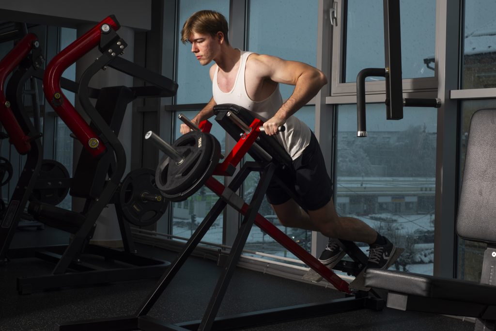 Tréner Oliver Vaňko predvádza cvičenie príťahov v ENERGYM posilňovni
